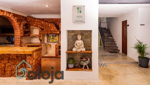 A guest house interior with a stone fireplace, a Buddha statue, and a staircase leading to another level. - VICA GUEST HOUSE (Cancun)