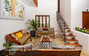 A spacious living area with a sofa set, a coffee table, and a staircase. - VICA GUEST HOUSE (Cancun)