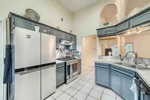 Enjoy cooking in this well-equipped kitchen with a refrigerator, stove, and oven, along with a spacious island and sink.