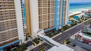 Un hôtel à plusieurs étages doté d’un atrium central, d’un parking et offrant une vue sur la plage.