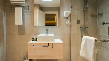 Une salle de bain moderne équipée d’un lavabo, d’un miroir, d’un porte-serviettes et d’une douche.