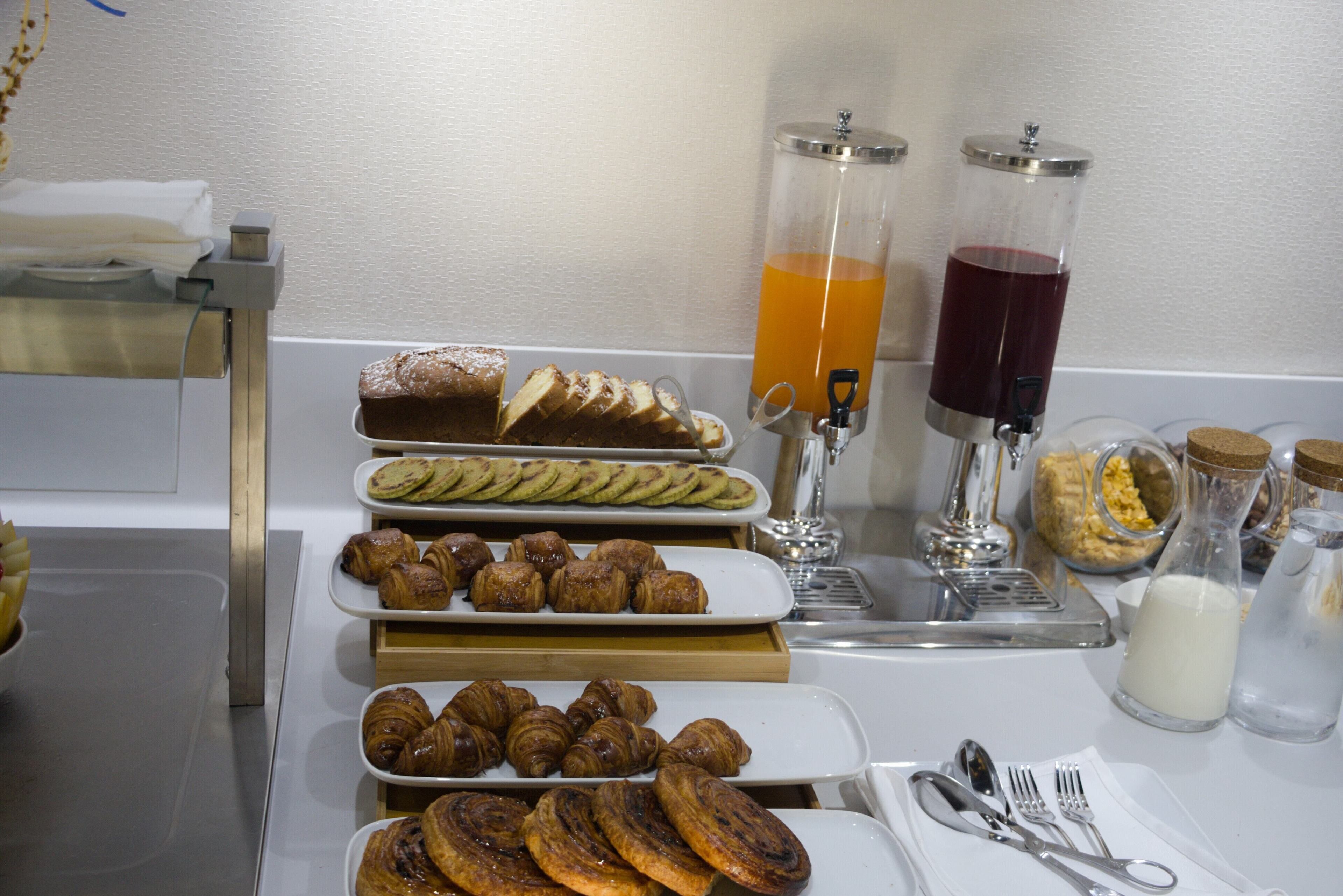 A breakfast buffet with various pastries and beverages.