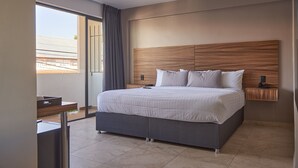 Un dormitorio moderno con una cama grande, una mesita de noche y vistas al exterior.