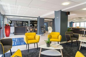 A modern hotel lobby with seating areas, a reception desk, and a bar. - Best Western Les Aureliades (Trignac)