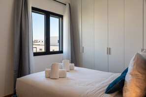 A hotel room with a bed, a window with curtains, and a view of buildings outside. - Villa Monégasque, elegance & exclusive seaside getaway (Sérignan)