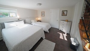 Une chambre avec deux lits, une commode, une poubelle et une fenêtre.