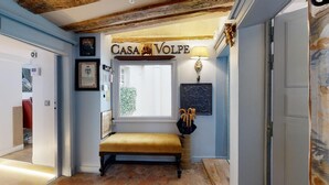En gang med en bænk, et vindue og et skilt med teksten 'CASA VOLPE'.
