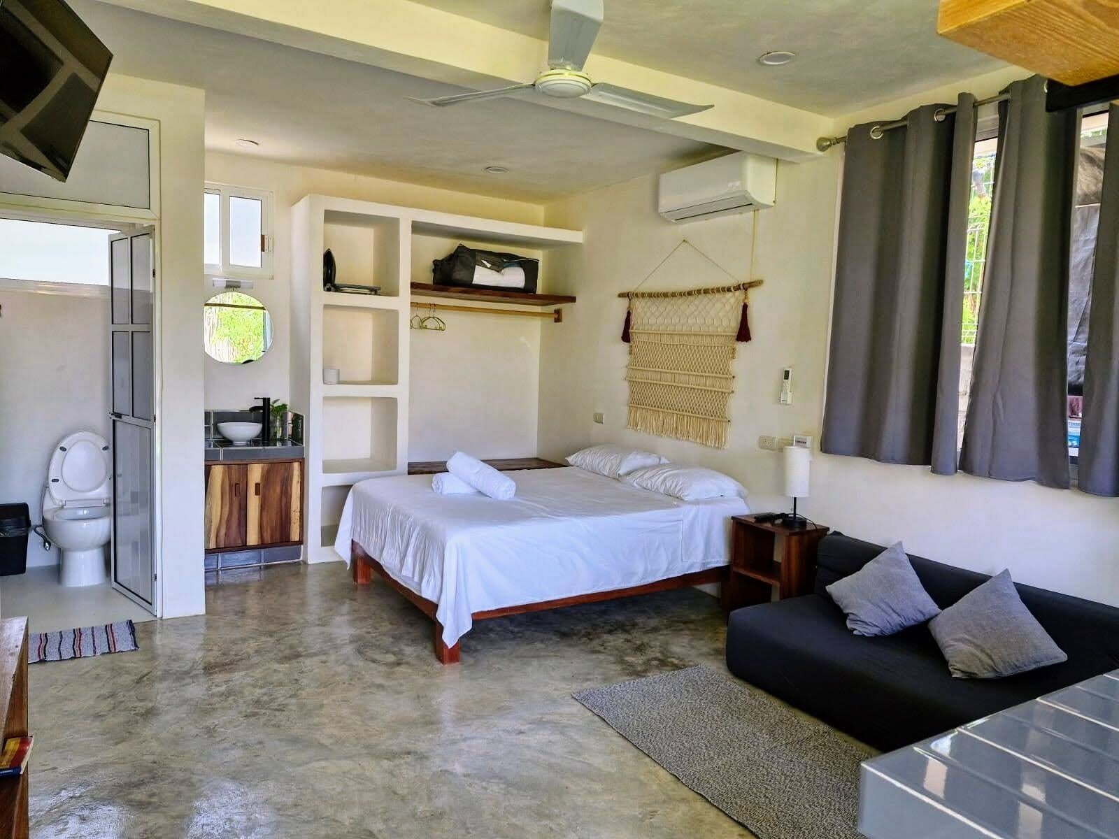 Une chambre à coucher avec un lit, une table de chevet et un canapé.