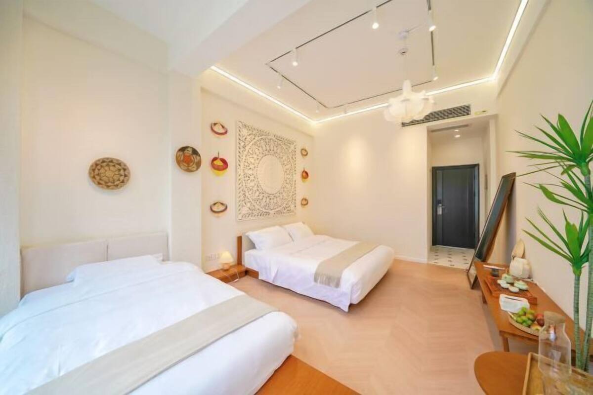 Una habitación de hotel moderna con dos camas, un comedor y un espejo grande.