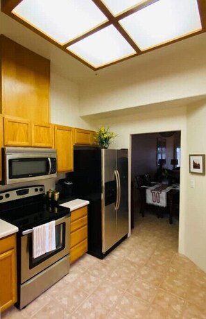 Enjoy meals in this kitchen with a refrigerator, microwave, and oven, adjacent to a dining area for two.