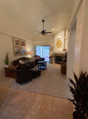 Relax in this cozy living space with a fireplace, sofa, and framed artwork.