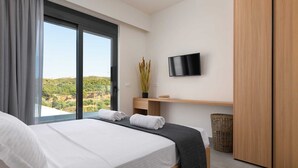 Une chambre à coucher avec un lit, une télévision, un bureau et une vue sur le paysage.
