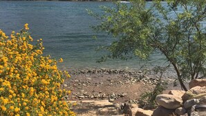 A rocky shoreline with a clear view of a lake and distant mountains. - Margaritaville at River Lodge! Right on the river! (Parker Dam)