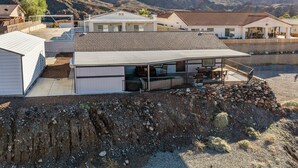 A modern building with a covered patio area, a swimming pool, and a view of mountains. - Bayview Beauty! Private River access and mountain views! (Parker)