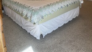 A bedroom with a large bed, a nightstand, a lamp, and a door leading to another room. - Shoshone One Bedroom with Lake and Pool Views (Lake Havasu City)