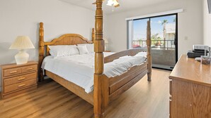 Una camera da letto con un letto a baldacchino, un comodino, una lampada e una ventola a soffitto.