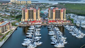 A marina with numerous boats docked, surrounded by high-rise buildings and a waterfront view. - Condo w/ Views & Resort Amenities in Cape Harbour! (Cape Coral)
