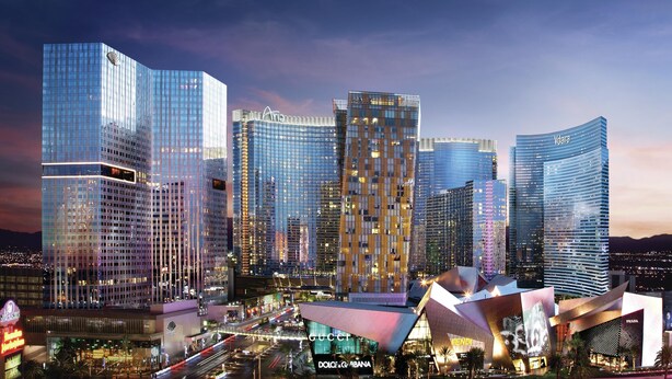 A modern cityscape with high-rise buildings, including a prominent curved structure with a digital display. - Gorgeous Suites Vdara (Las Vegas)
