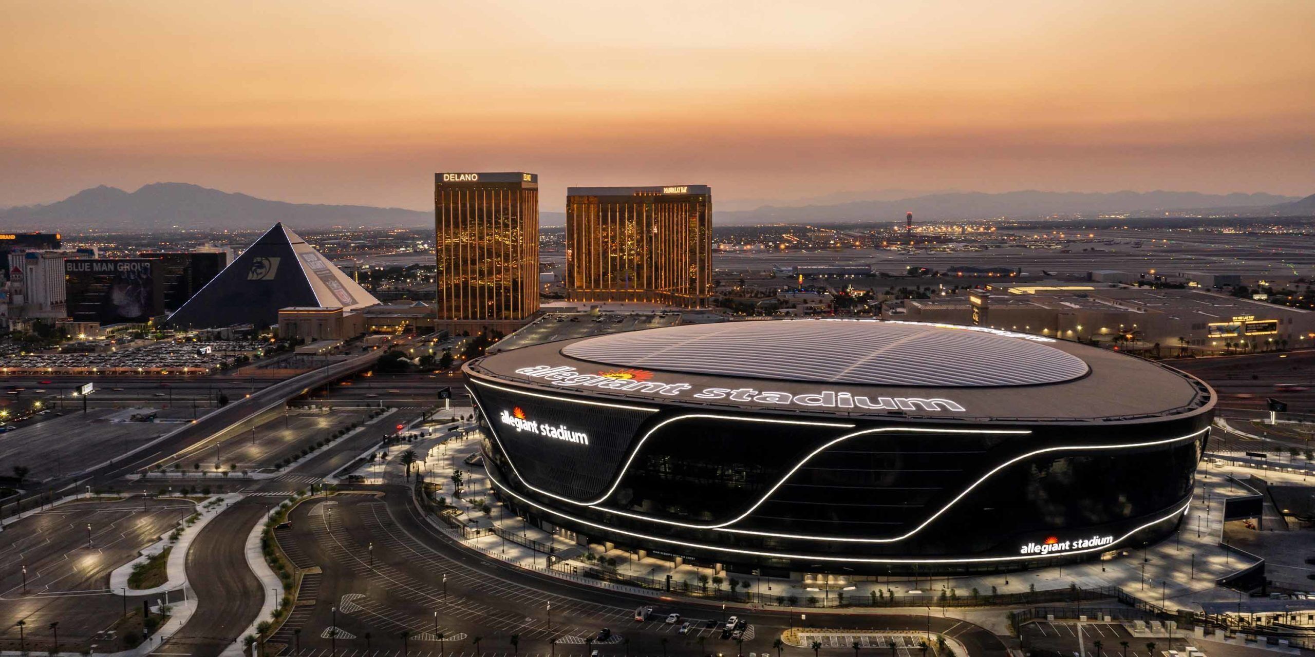 Moderni stadion, jossa on kaareva katto ja sen nimikyltissä lukee ”Allegiant Stadium”.
