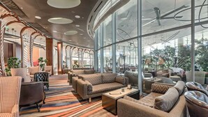 A modern lounge area with sofas and armchairs, large windows, and a patterned carpet. - Gorgeous Suites Vdara (Las Vegas)