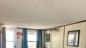 A furnished living room with a sofa, armchair, coffee table, and wooden dining table. - Cabin by lake, pet friendly, quiet (Hot Springs)