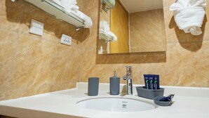 A bathroom with a sink, mirror, towel rack, and toiletries. - Tranquil Villa in Jolly Harbour with Pool & Modern Amenities (St. Mary's)