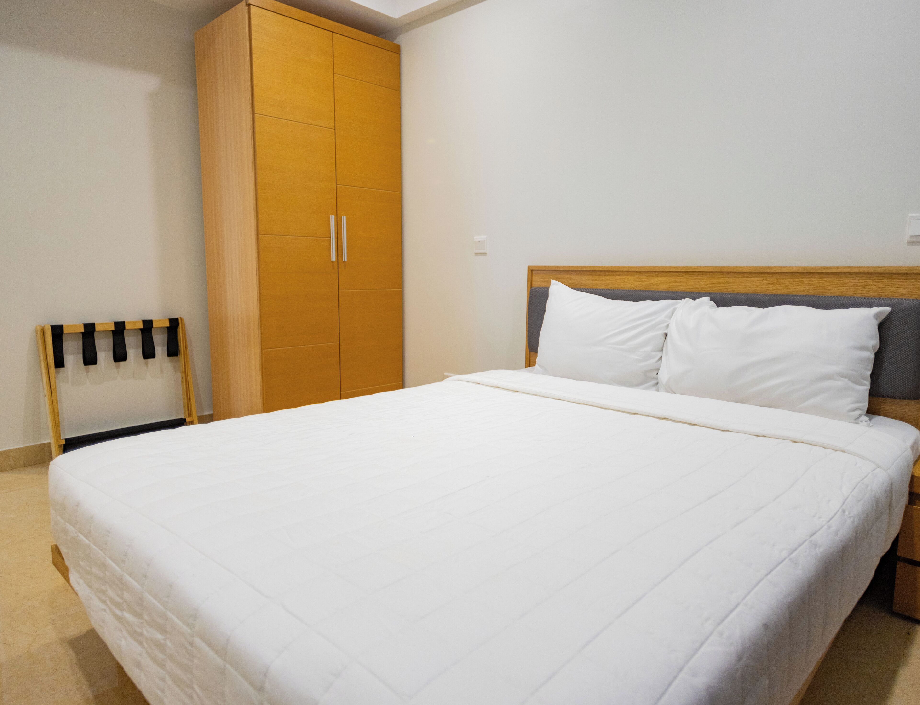 Ein Schlafzimmer mit einem großen Bett, einem Kleiderschrank und einem kleinen Stuhl.