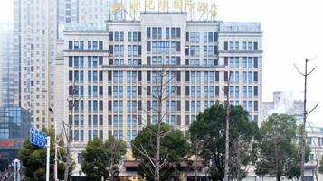 A multi-story building with a symmetrical facade, large windows, and a flat roof.
