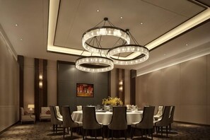 A conference room with a round table, chairs, and a chandelier. - Century Yuan International hotel(Jiangyan,Taizhou) (Taizhou)