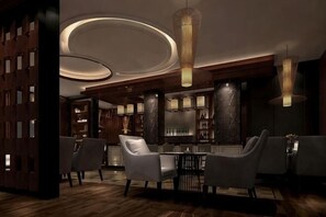 Un interior moderno con una zona de bar, asientos y suelo de madera.