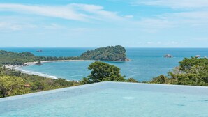 A clear view of a tropical beach with a small island, a pool, and lush greenery. - Villa&Tower -17 Bdrms,sleeps 55-AC,Elevator,Pool (Quepos)