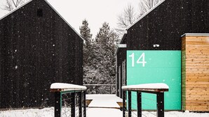 Caminho coberto de neve que leva a um edifício com uma placa verde exibindo o número 14.