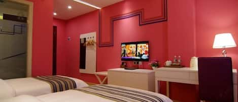 A hotel room with two beds, a desk, a TV, and a chair.