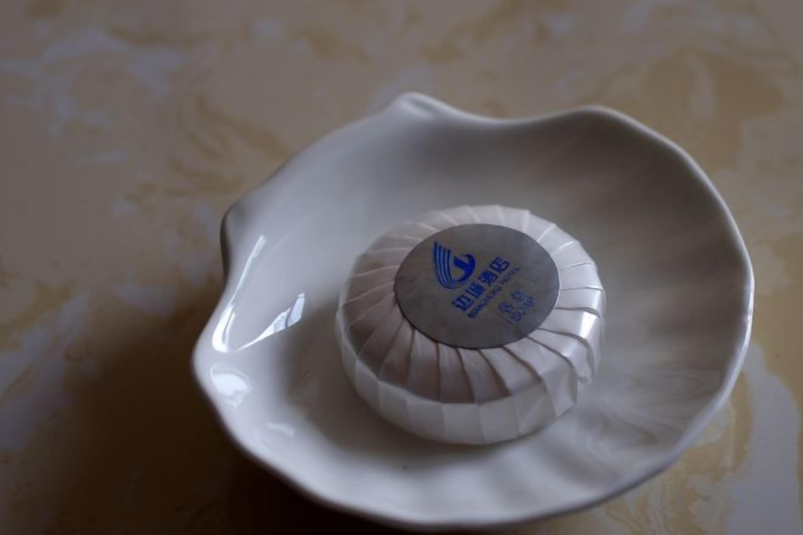 Een witte keramieken kom met deksel op een tafel.