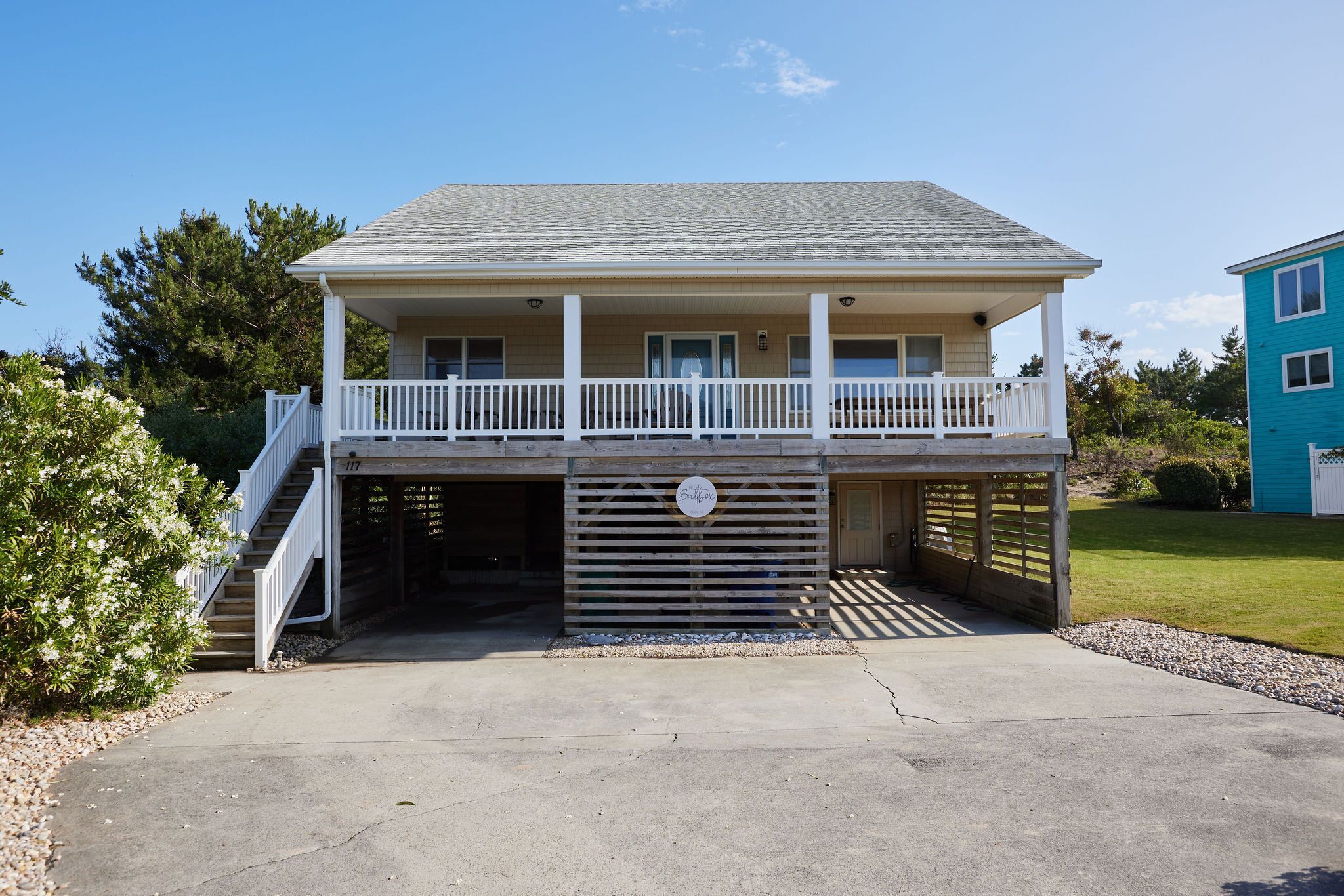A two-story building with a covered porch and a staircase leading to the upper level.