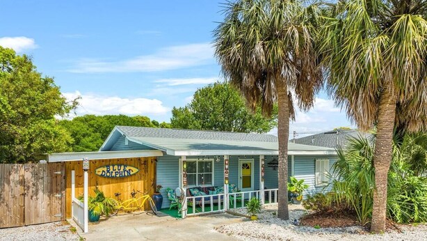 A small building with a porch and a sign that reads "Blue Dolphin."