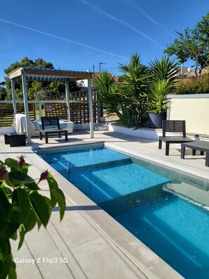 A swimming pool with lounge chairs and a covered seating area. - tiny house in the nature , near of beautiful beaches (Setubal)