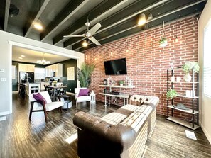 Relax in this stylish living space with a brick accent wall, flat-screen TV, and comfortable seating area.