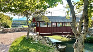 A wooden bridge over a pond, surrounded by trees and a stone wall. - Charming updated LOFT style townhouse!!! (Midvale)
