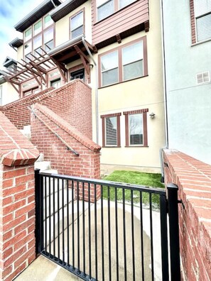 Stunning residential building with a brick exterior, featuring multiple windows with brown shutters and a brick chimney.