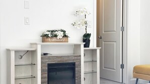 A modern living room with a fireplace, a bench, and a door.