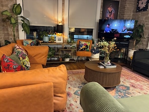 A cozy living room with a sofa, a coffee table, and a television. - WorldCup Central- Easy access for sports and entertainment. (Houston)