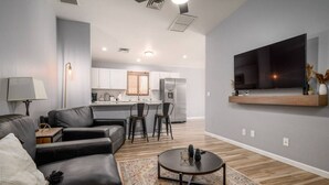 Una sala de estar moderna con un sofá, una mesa de centro y un televisor montado en la pared.
