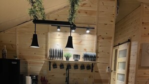 Een moderne keuken met houten wanden, een centraal eiland, hanglampen en een inbouwoven.