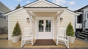 A house with a white exterior, a double door, and two white rocking chairs in front. - Charming Downtown Cottage w/ Modern Amenities (Coeur d'Alene)