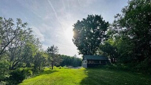 A small house surrounded by lush greenery and trees.