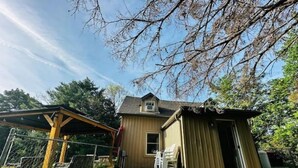 A two-story house with a covered patio and a shed.