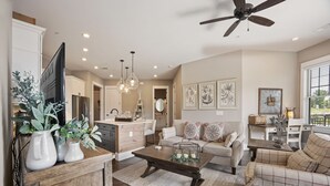 A spacious living area with a sofa, coffee table, and decorative plants.