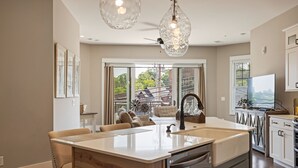 A modern kitchen with a central island, built-in appliances, and a large window offering a view of the outdoors.