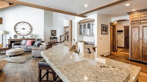 A spacious living room with a large sofa, a coffee table, and a dining area with a granite countertop. - Beautiful, Comfortable, Well Appointed House; Amazing Views, Excellent Location (Park City)